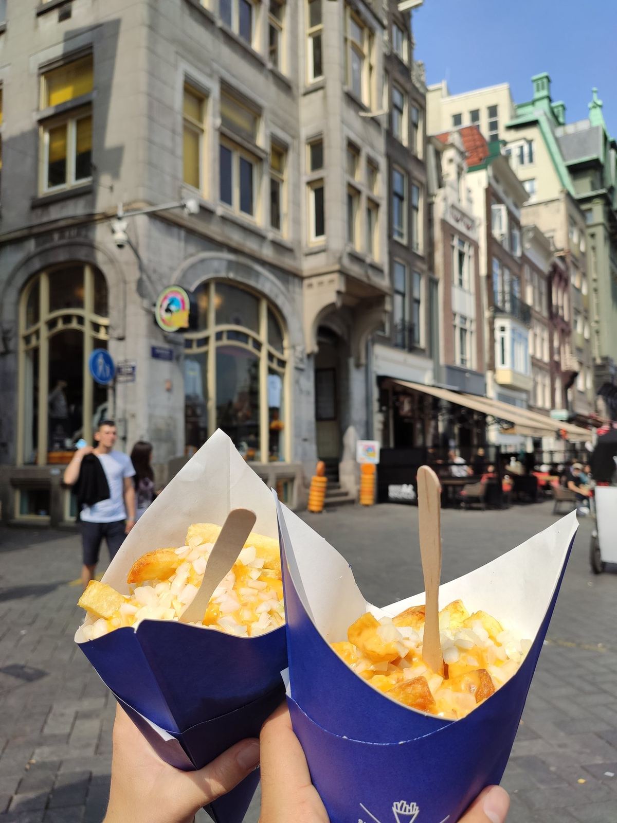 Zwei Pommes-Tüten vor einer Stadtstraße