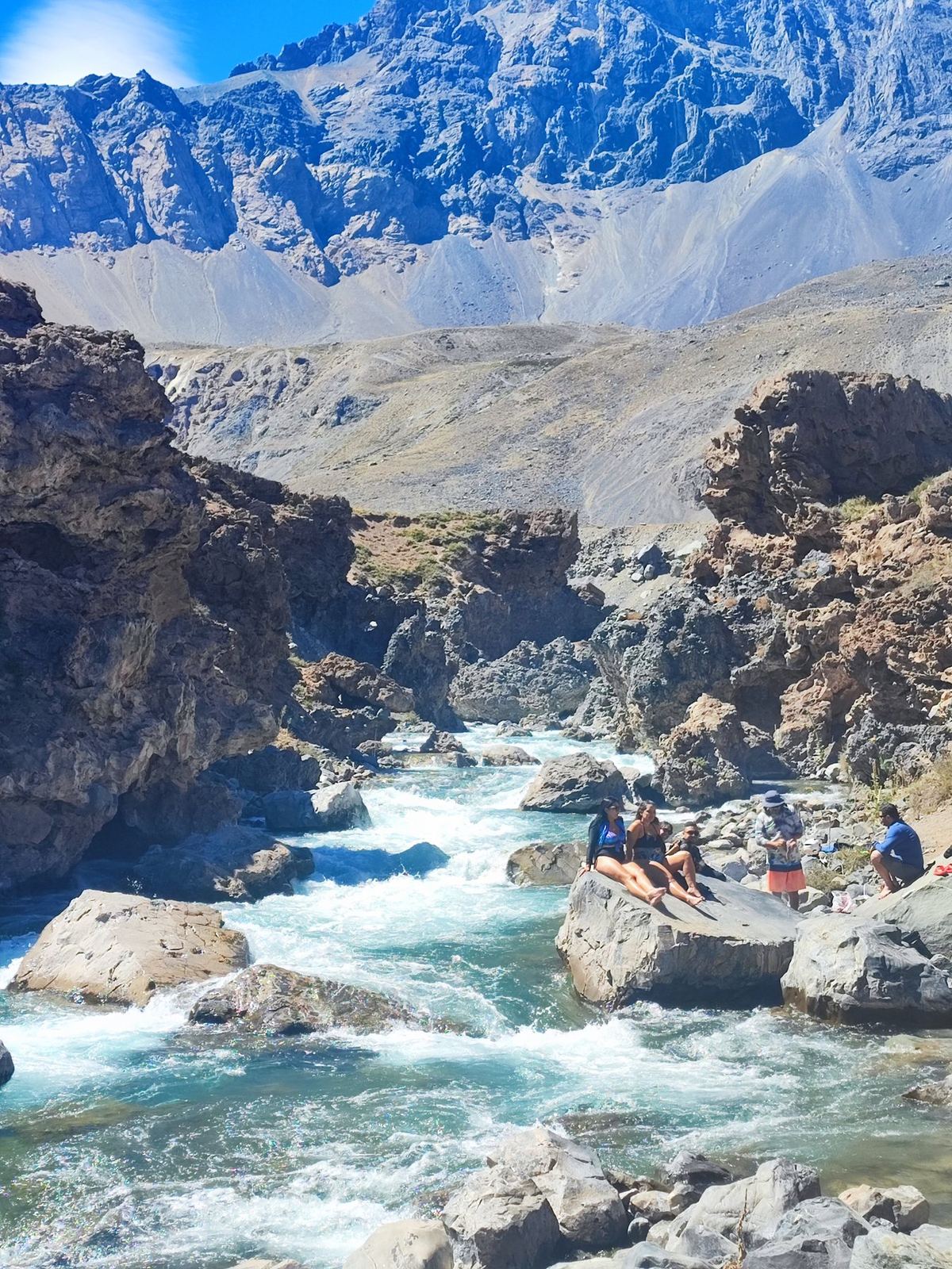 Ein Bergfluss, Menschen ruhen auf den Felsen