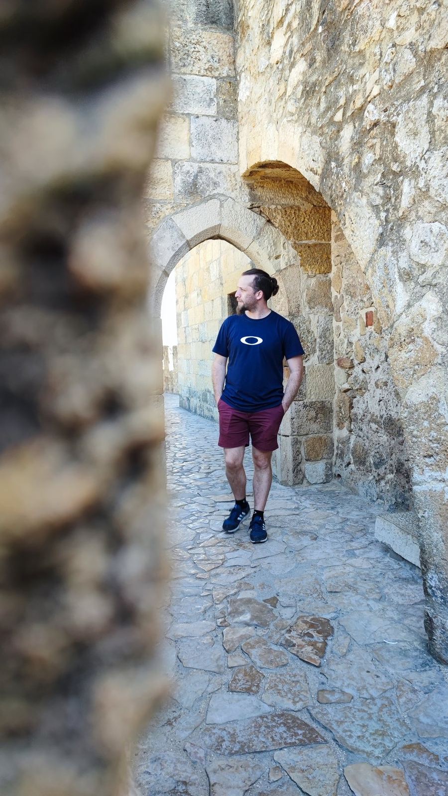 Nicolás geht durch einen steinernen Burgbogen