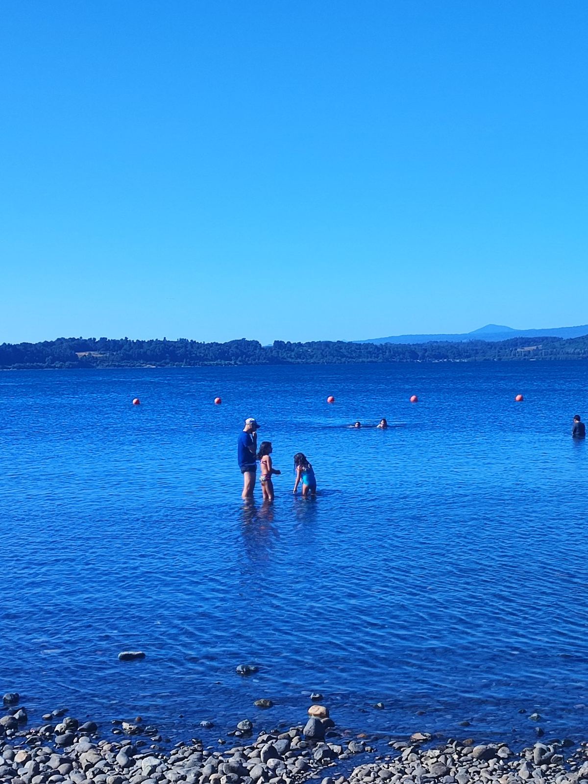 Personas caminando en un lago azul y transparente