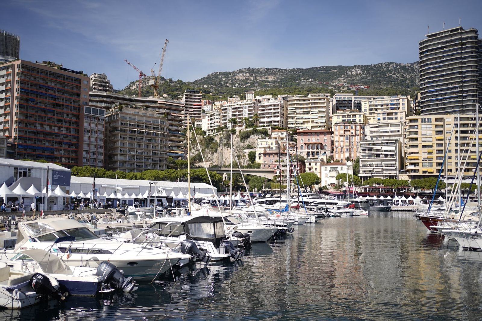Yachts moored in a harbour below hillside buildings