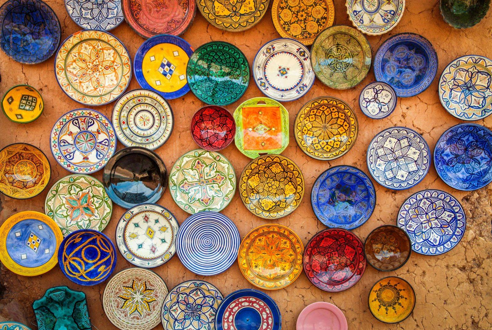 Hand-painted ceramic plates hanging on a clay wall