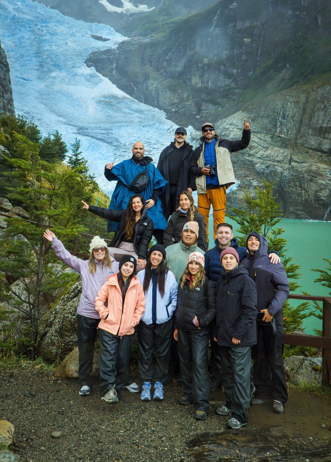 Un grupo pequeño de viajeros posando frente a un glaciar