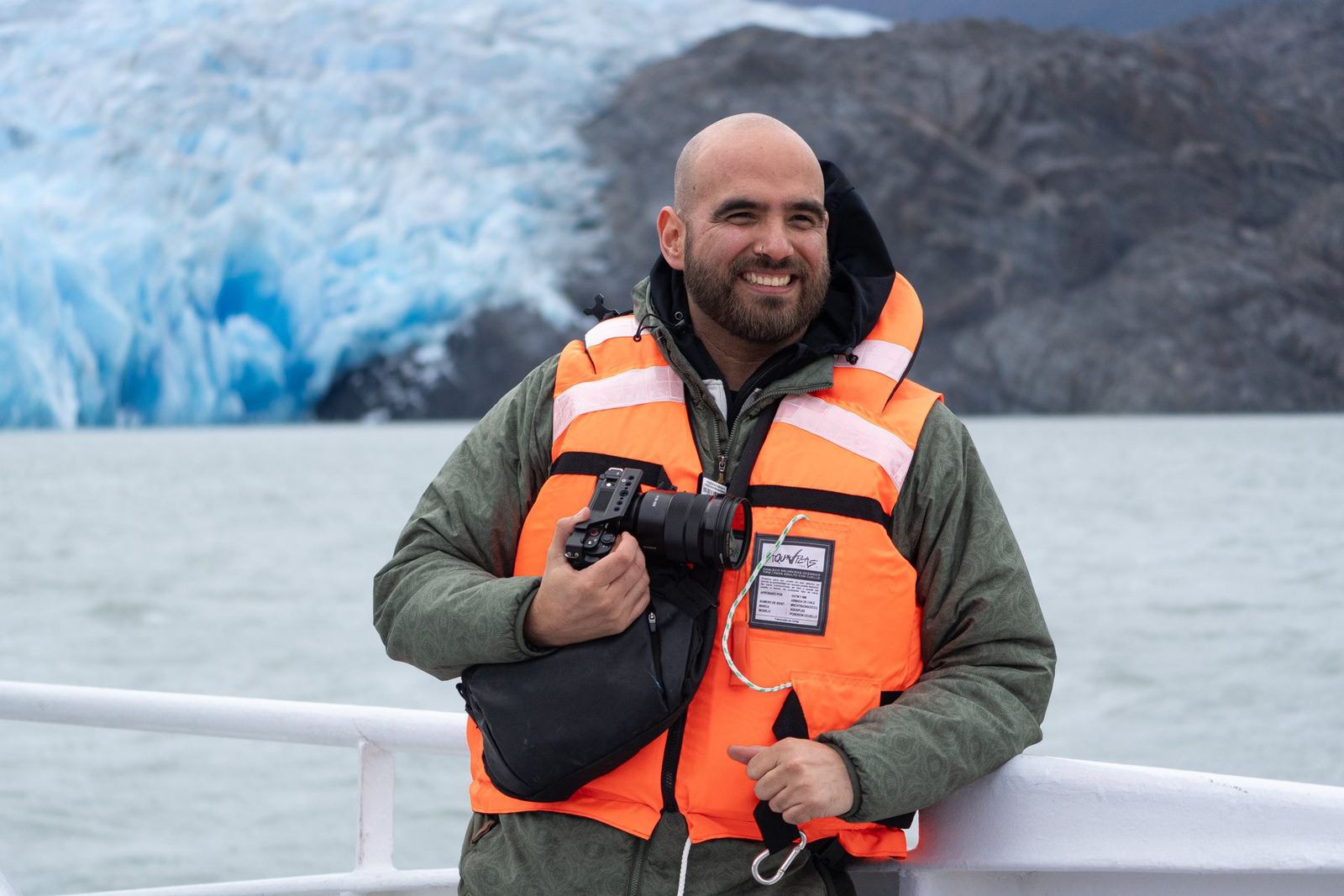Nicolás Lacoste con su cámara en un bote frente a un glaciar