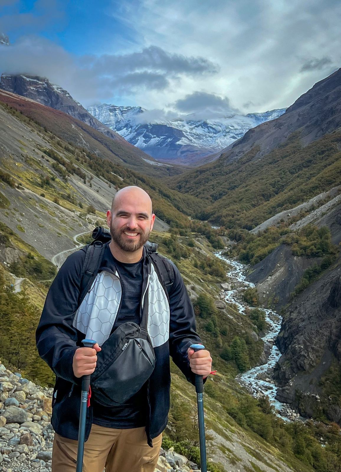 Nicolás mit Trekkingstöcken über einem Flusstal