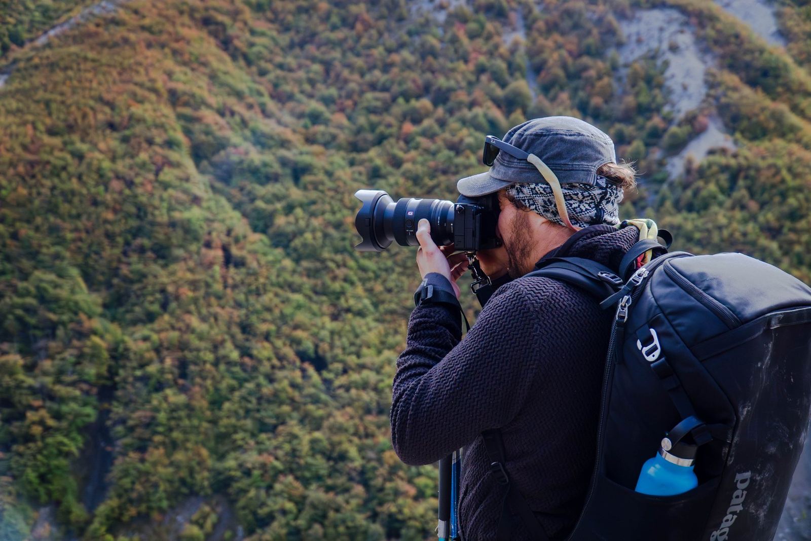 Un fotógrafo encuadrando sobre un valle de montaña