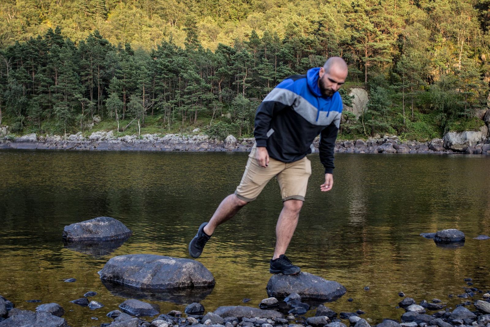 Ein Reisender springt über Steine im Fluss